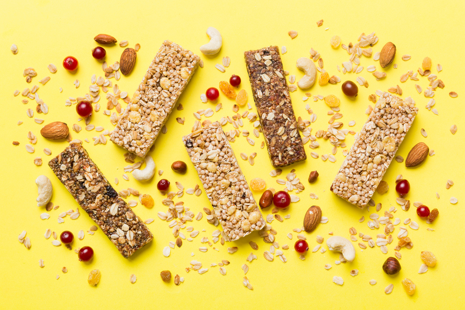 Various granola bars on table background. Cereal granola bars. Superfood breakfast bars with oats, nuts and berries, close up. Superfood concept